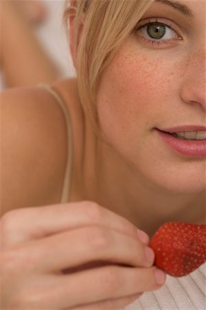 portrait of woman with fruit on head - Femme tenant une fraise dans sa main, gros plan Photographie de stock - Premium Libres de Droits, Code: 628-00918846