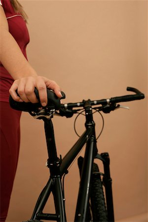A female mountain biker holding her mountain bike Stock Photo - Premium Royalty-Free, Code: 628-00919003