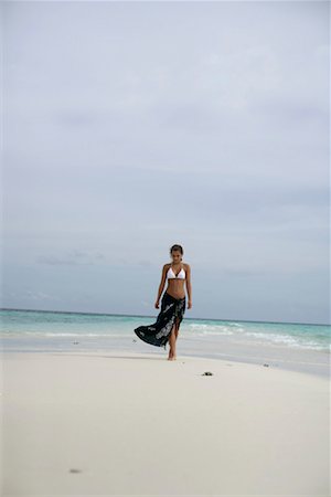 Young girl wearing bikini and pareo, walking along the beach Stock Photo - Premium Royalty-Free, Code: 628-00919174