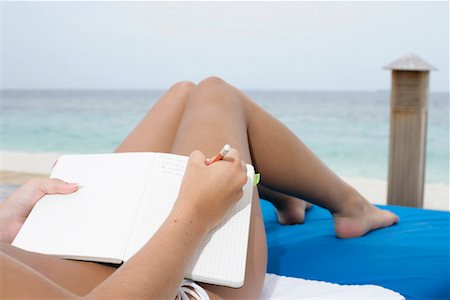 Young girl lying at deck chair, writing holiday diary Stock Photo - Premium Royalty-Free, Code: 628-00919179