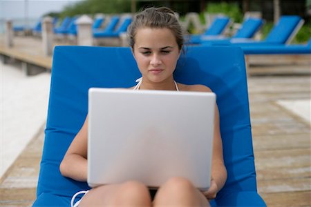 simsearch:628-00919233,k - Young girl sitting on a deck chair, using laptop Stock Photo - Premium Royalty-Free, Code: 628-00919198