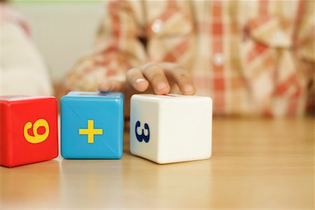 Child playing with building blocks with numbers Stock Photo - Premium Royalty-Free, Code: 628-00919255