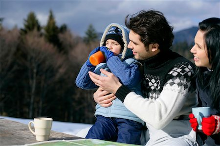 Couple drinking coffee, father helping son to drink juice Stock Photo - Premium Royalty-Free, Code: 628-00919405
