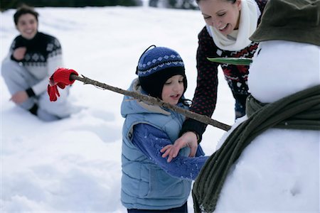 family with snowman - Family making a snowman Stock Photo - Premium Royalty-Free, Code: 628-00919450