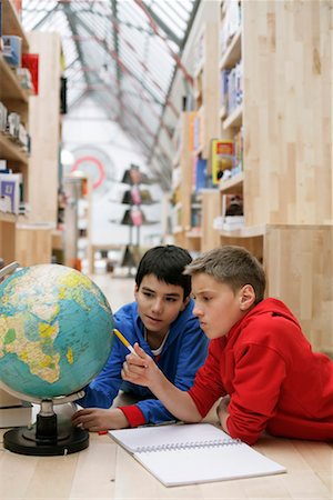 Two boys lying on the floor and looking at a globe, fully_released Stock Photo - Premium Royalty-Free, Code: 628-00919671