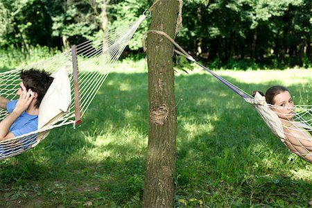 Young man and young woman are lying in hammocks Stock Photo - Premium Royalty-Free, Code: 628-00919697