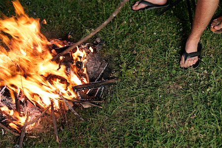 flip flops close - Young man is sitting close to a campfire Stock Photo - Premium Royalty-Free, Code: 628-00919702