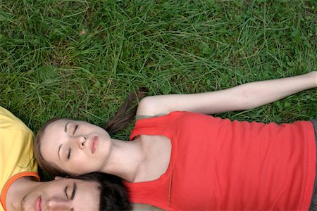 Young couple lying head to head on grass, eyes closed Stock Photo - Premium Royalty-Free, Code: 628-00919734