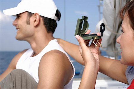 friends sailing - Woman putting her hand on man's shoulder, using a compass Stock Photo - Premium Royalty-Free, Code: 628-00919890