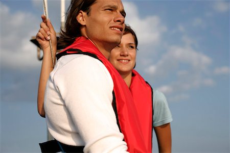 friends sailing - Couple wearing life jackets on a sailboat Stock Photo - Premium Royalty-Free, Code: 628-00919900