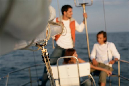 friends sailing - Two men and a woman on a sailboat Stock Photo - Premium Royalty-Free, Code: 628-00919915