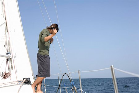 Man standing on a sailboat Stock Photo - Premium Royalty-Free, Code: 628-00919934