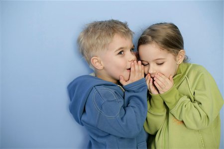 Little boy whispering in girl's ear Stock Photo - Premium Royalty-Free, Code: 628-00920049
