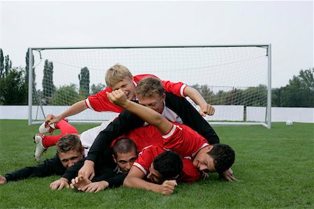 football team celebration - Soccer players lying in a crowd on grass Stock Photo - Premium Royalty-Free, Code: 628-00920077