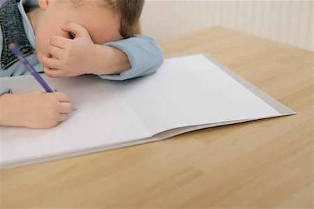 Boy drawing, covering his face with hand Stock Photo - Premium Royalty-Free, Code: 628-00920104