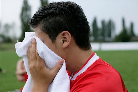 Soccer player drying his face by a towel Stock Photo - Premium Royalty-Free, Code: 628-00920177