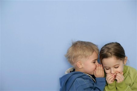 Little boy whispering in girl's ear Stock Photo - Premium Royalty-Free, Code: 628-00920170