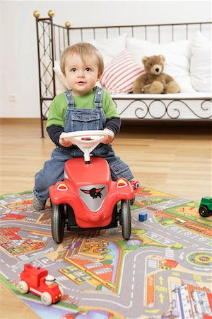 Baby boy sitting on a bobby car Stock Photo - Premium Royalty-Free, Code: 628-00920374