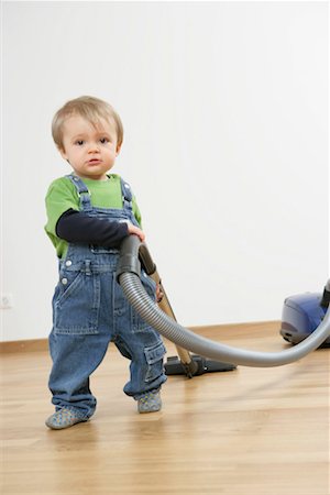 Baby boy playing with a vacuum cleaner Stock Photo - Premium Royalty-Free, Code: 628-00920384