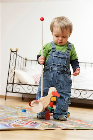 Baby boy playing with a wooden toy Stock Photo - Premium Royalty-Free, Code: 628-00920383