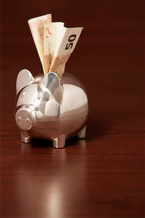 simsearch:628-03201079,k - Silver piggybank with a bill sticking in it's back, close-up Stock Photo - Premium Royalty-Free, Code: 628-00920428