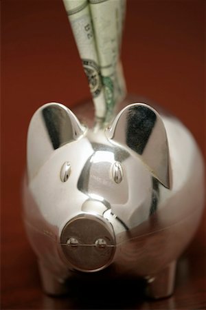 simsearch:628-03201079,k - Silver piggybank with a bill sticking in it's back, close-up Stock Photo - Premium Royalty-Free, Code: 628-00920486