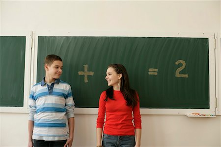 Two pupils standing in front of a blackboard, arithmetic problem in background Stock Photo - Premium Royalty-Free, Code: 628-00920590