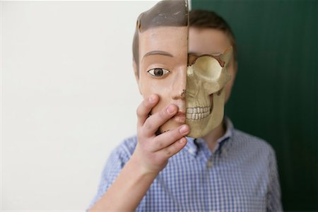 Teenage boy holding a model of a human head in his hand Stock Photo - Premium Royalty-Free, Code: 628-00920602