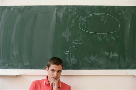 simsearch:628-00920637,k - Reflective teenage boy in front of a blackboard, balloon on blackboard Stock Photo - Premium Royalty-Free, Code: 628-00920632