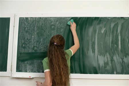 Teenage girl cleaning a blackboard Stock Photo - Premium Royalty-Free, Code: 628-00920644