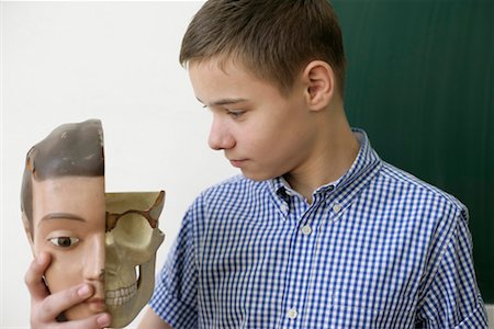 Teenage boy holding a model of a human head in his hand Stock Photo - Premium Royalty-Free, Code: 628-00920666