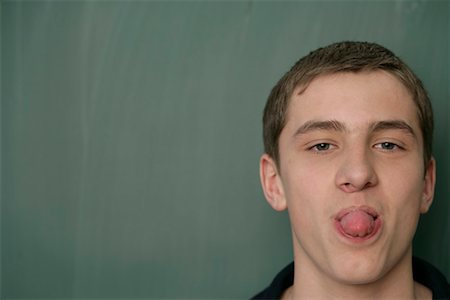 Teenage boy sticking out his tongue Foto de stock - Sin royalties Premium, Código: 628-00920674