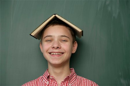 simsearch:628-00920637,k - Teenage boy with a book on his head laughing at camera Stock Photo - Premium Royalty-Free, Code: 628-00920682