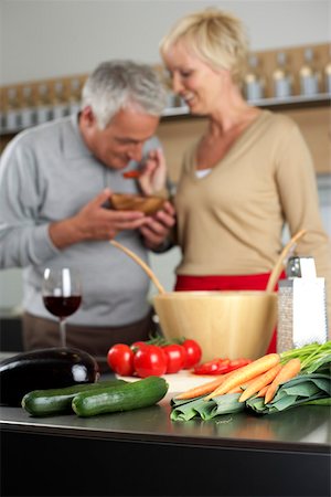 simsearch:628-01279142,k - Blonde woman lets a gray-haired man taste something she has cooked, selective focus Foto de stock - Royalty Free Premium, Número: 628-01278235