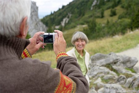 Senior adult man taking a picture of his wife in the mountains, selective focus Stock Photo - Premium Royalty-Free, Code: 628-01278310
