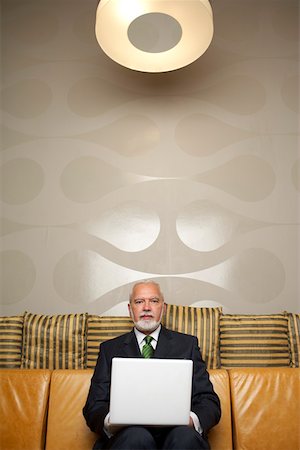 simsearch:628-01278542,k - Mature businessman sitting on a sofa using a laptop Stock Photo - Premium Royalty-Free, Code: 628-01278338