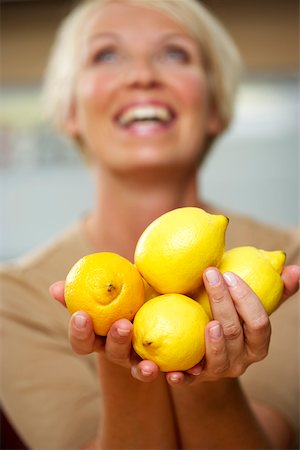 Mature woman holding a medium group of lemons in her hands, close-up Foto de stock - Sin royalties Premium, Código: 628-01278348