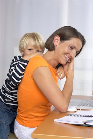 simsearch:628-01279508,k - Mother phoning with a mobile phone while son (4-5 Years) embracing her form behind Stock Photo - Premium Royalty-Free, Code: 628-01278386