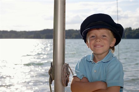 Little boy with a captain-hat is standing next to a rod, close-up Stock Photo - Premium Royalty-Free, Code: 628-01278404