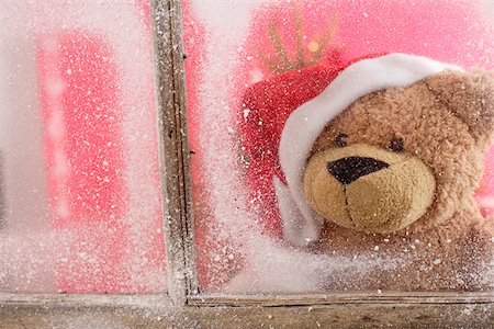 Teddy bear wearing Santa Claus hat looking out of a window Stock Photo - Premium Royalty-Free, Code: 628-01278444