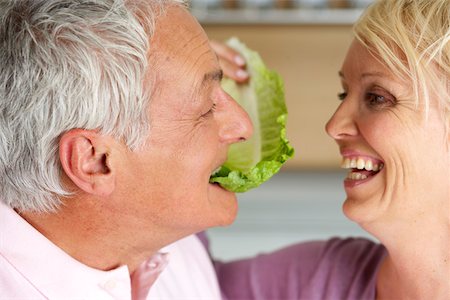 simsearch:628-01279142,k - Blonde woman feeding a grey- haired man with a lettuce leaf, close-up Foto de stock - Royalty Free Premium, Número: 628-01278449