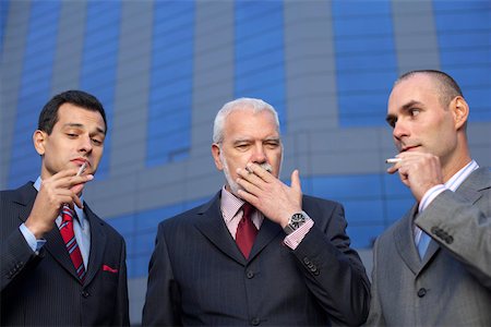 smoke in front of black - Three businessmen smoking in front of an office building Stock Photo - Premium Royalty-Free, Code: 628-01278542