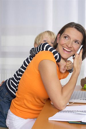 simsearch:628-01279508,k - Mother phoning with a mobile phone, son (4-5 Years) embracing her form behind Stock Photo - Premium Royalty-Free, Code: 628-01278585