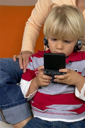 simsearch:628-01279508,k - Boy (4-5 Years) playing hand held computer game, mother sitting in background Stock Photo - Premium Royalty-Free, Code: 628-01278640