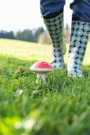 Person in rubber boots standing behind an artificial fly agaric, selective focus Foto de stock - Sin royalties Premium, Código: 628-01278641