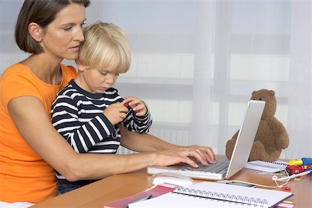 simsearch:628-01279508,k - Mother using a laptop while son (4-5 Years) sitting on her lap Stock Photo - Premium Royalty-Free, Code: 628-01278660