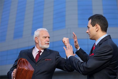 simsearch:628-01278542,k - Mature businessman with fist up, an other businessman holding hands up Stock Photo - Premium Royalty-Free, Code: 628-01278676