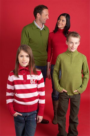 portrait of father and mother christmas - Portrait of a family in front of a red wall Stock Photo - Premium Royalty-Free, Code: 628-01278687