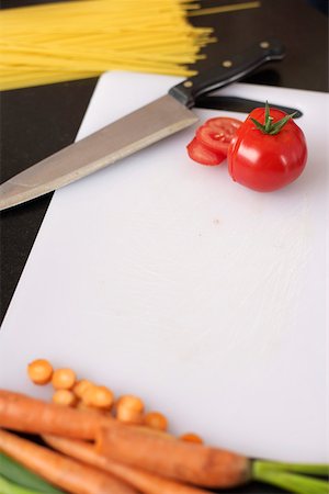 sharp objects - Tomato and carrots on a carving board next to a kitchen knife, high angle view Stock Photo - Premium Royalty-Free, Code: 628-01278717