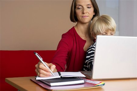 simsearch:628-01279508,k - Mother taking notes while son (4- 5 Years) sitting on her lap Stock Photo - Premium Royalty-Free, Code: 628-01278758